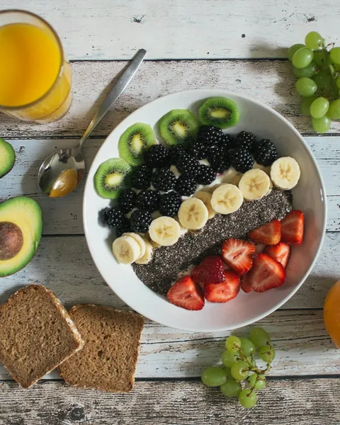 A bowl of fruit and yoghurt with wholegrain toast