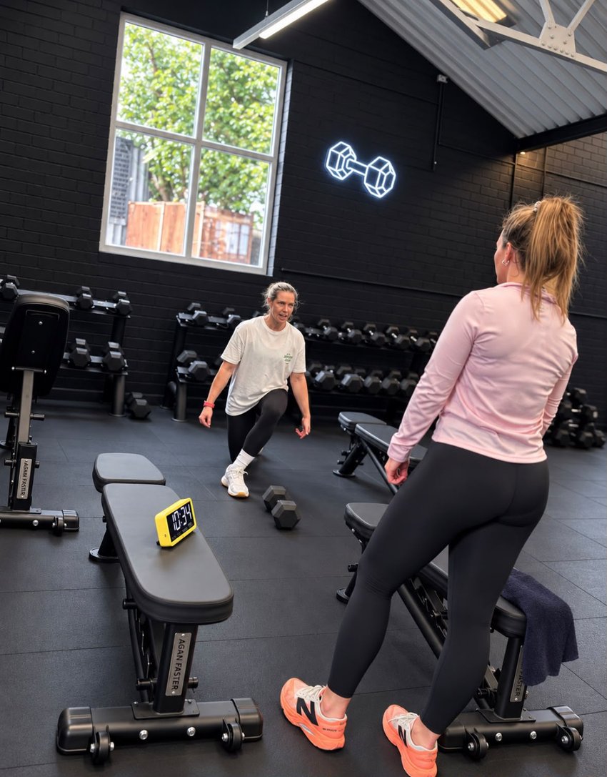 Lesley coaching a client through a workout in the gym